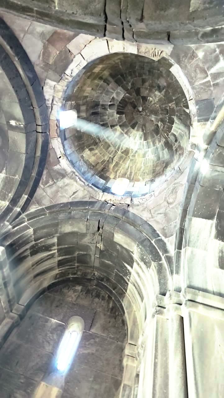 Light falling through the ribbed stone dome of an Armenian monastery