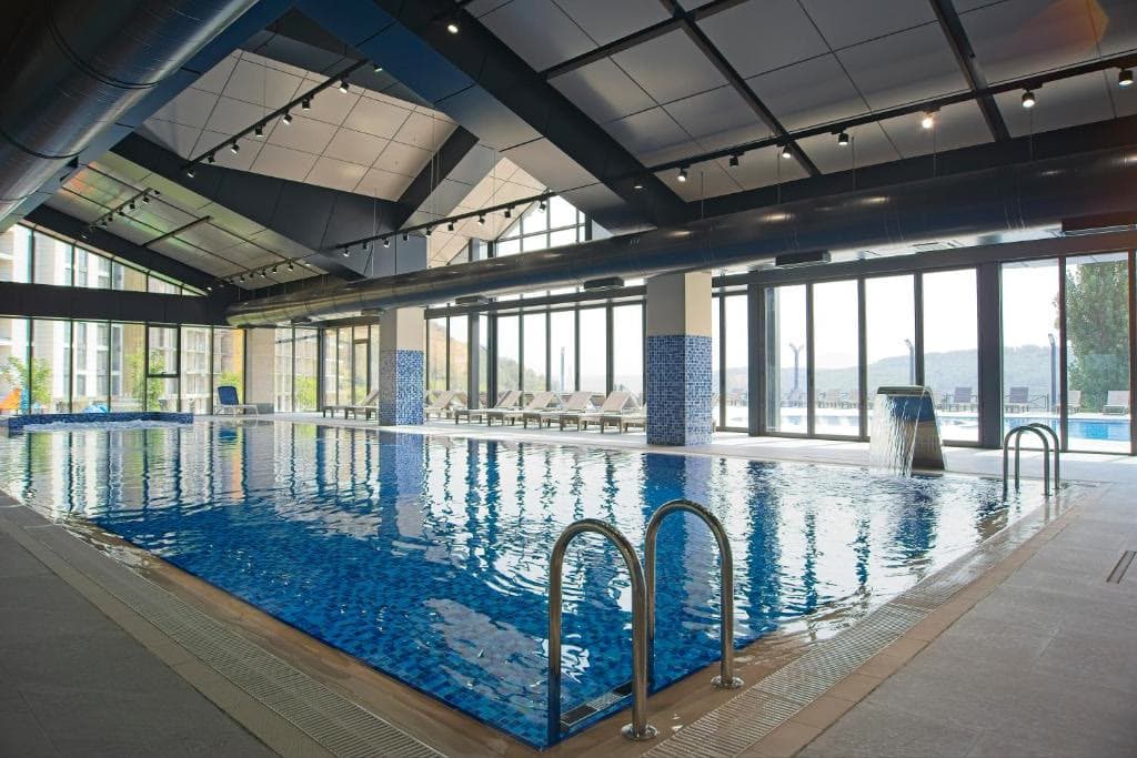 The hotel's indoor swimming pool beneath a full-height window wall