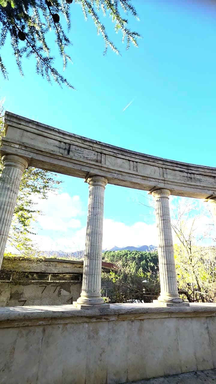 A stone colonnade opening onto forested hills in Tsaghkadzor