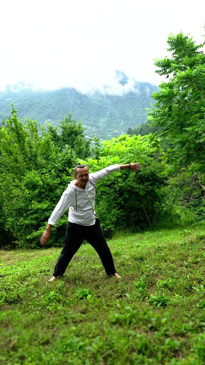 Standing practice on a mountain meadow with wooded hills behind