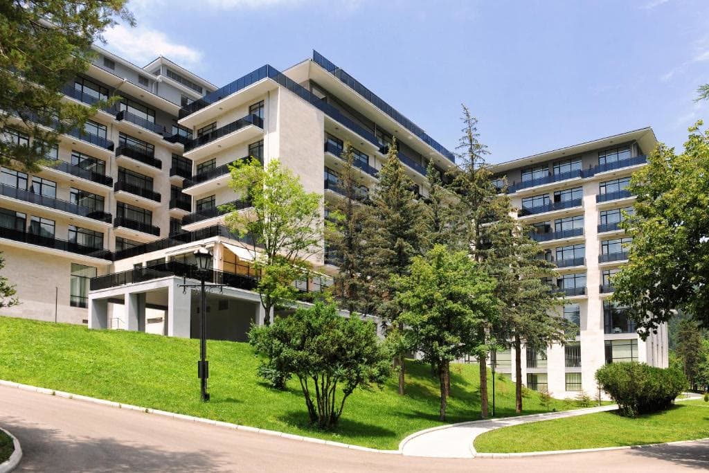 The hotel's long contemporary facade above a lawn and young trees