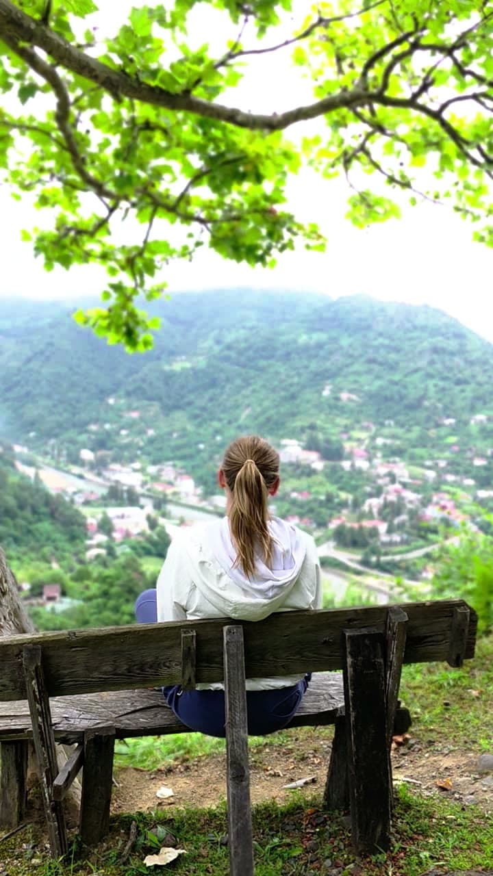 Sitting on a bench at the edge of a meadow, looking out over the valley